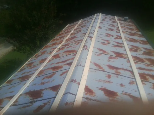 Rusted metal roof panels with new wood purlins before replacement — Storm Damage Roof Repair in Grantham by Roofing Brothers