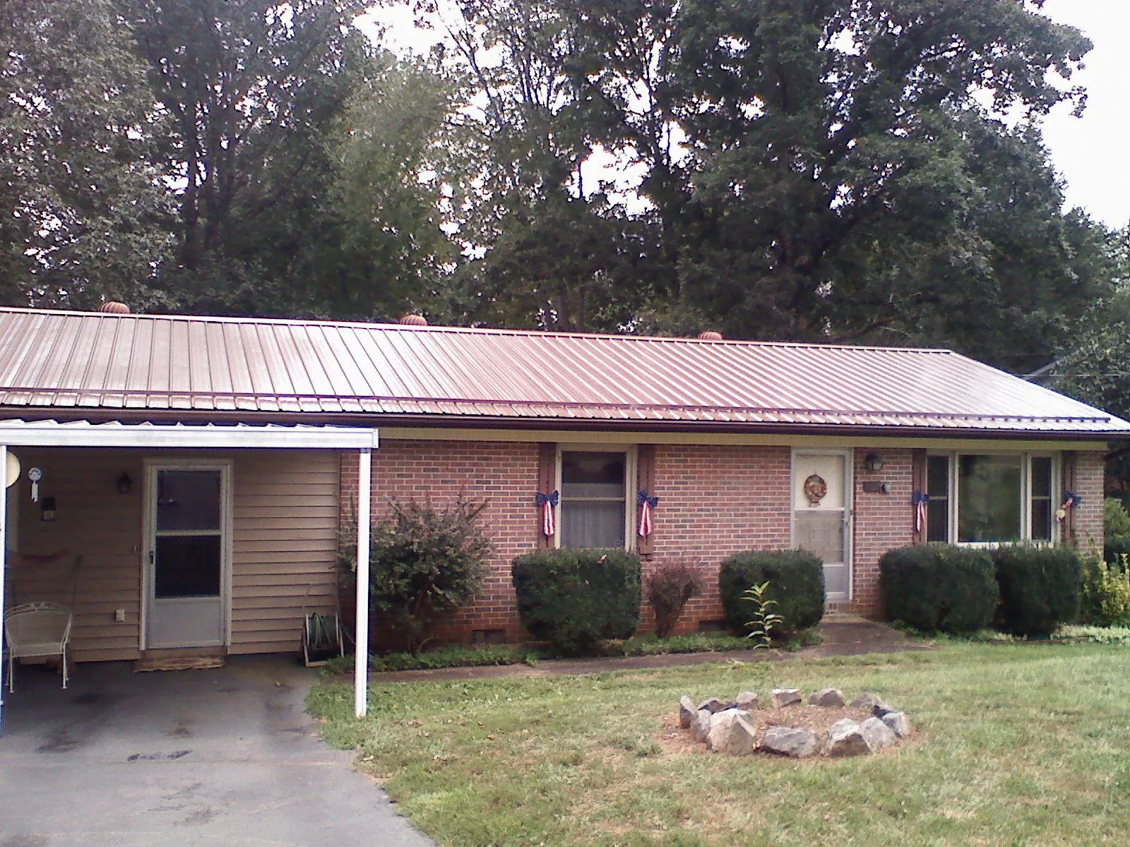Bronze metal roof and carport on a brick ranch home — Roof Repair work by our crew in Grantham